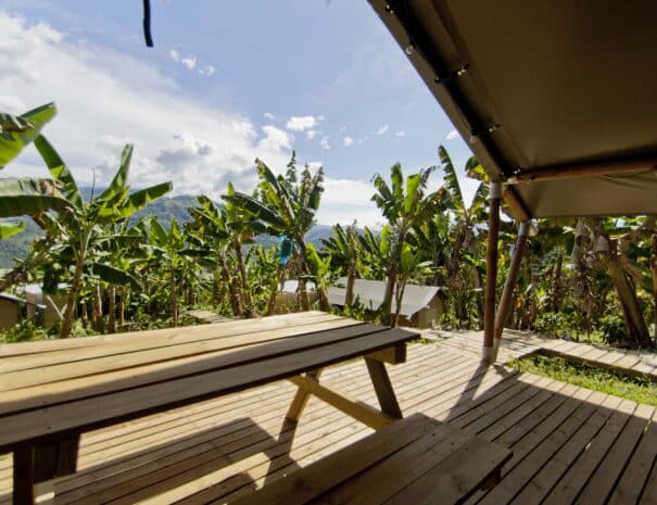 Views from a glamping tent with pick-nick table, mountains and banana trees